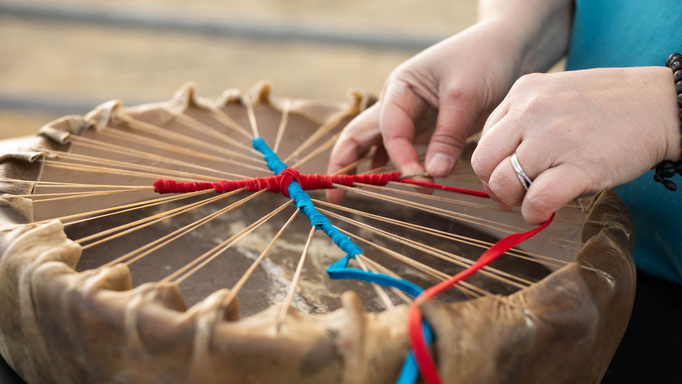 Hands using a shamanic drum for journeying and distance energy healing